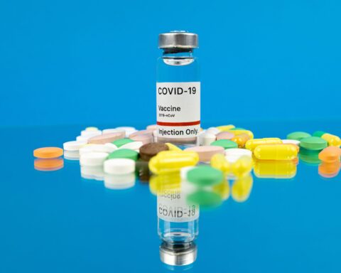 white labeled vaccine bottle on blue background